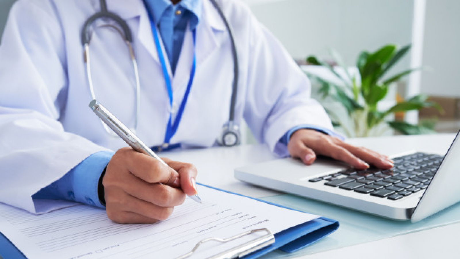maos-da-medica-irreconhecivel-escrevendo-no-formulario-e-digitando-no-teclado-do-laptop_1098-20374